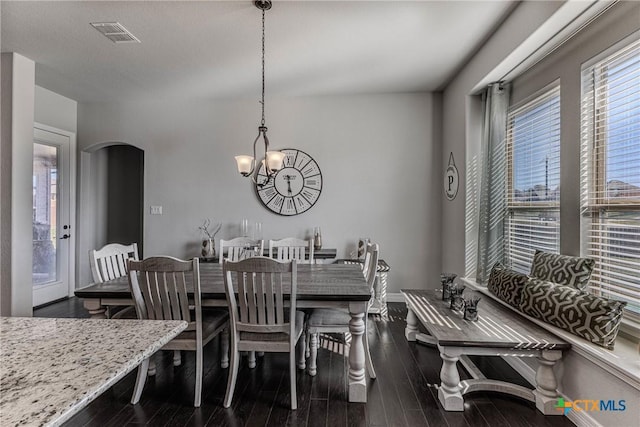 dining space with dark hardwood / wood-style floors and a chandelier