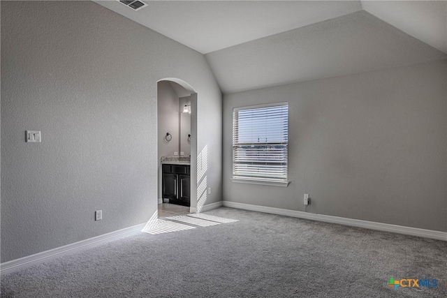 unfurnished living room with carpet floors and vaulted ceiling