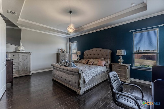 bedroom featuring ceiling fan, dark hardwood / wood-style flooring, ornamental molding, and a tray ceiling