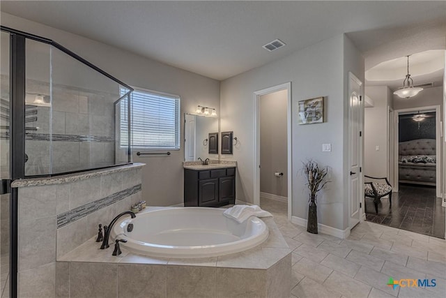 bathroom featuring shower with separate bathtub and vanity