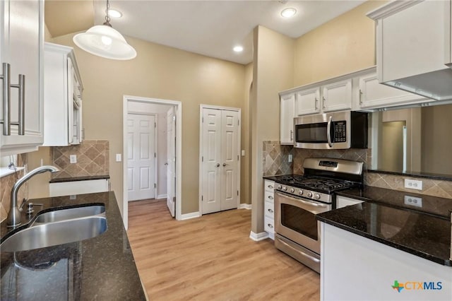 453 Raven Rdg, New Braunfels, TX 78130 - kitchen featuring appliances with stainless steel finishes, a sink, white cabinets, light wood-style floors, and hanging light fixtures
