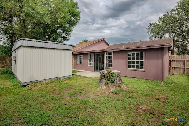 back of house featuring an outbuilding and a lawn