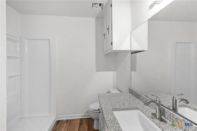 bathroom with hardwood / wood-style floors, vanity, and toilet