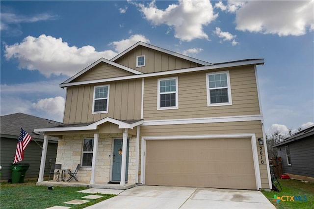 view of front of house featuring board and batten siding, stone siding, driveway, and a garage