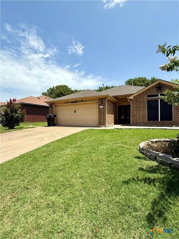 1828 Winchester Dr, Temple, TX 76502 - ranch-style house with driveway, a garage, roof with shingles, brick siding, and a front yard