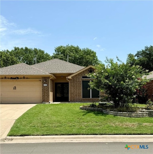 1828 Winchester Dr, Temple, TX 76502 - ranch-style house featuring driveway, a shingled roof, a garage, a front yard, and brick siding