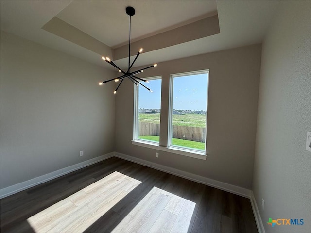 4015 Prairie Dr, Nolanville, TX 76559 - empty room with a chandelier, baseboards, dark wood finished floors, and a raised ceiling