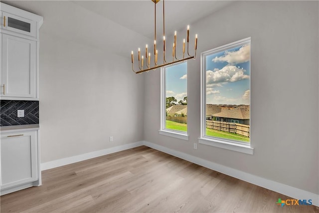 4015 Prairie Dr, Nolanville, TX 76559 - unfurnished dining area with light wood-style flooring, baseboards, and a chandelier