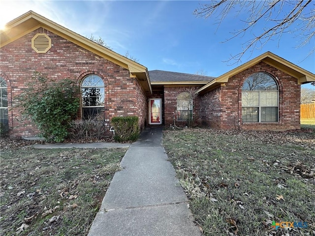 single story home with a front yard and brick siding