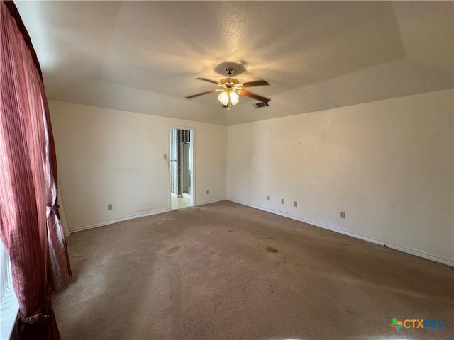 spare room featuring visible vents, carpet flooring, a ceiling fan, and baseboards