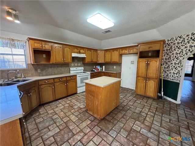 kitchen featuring under cabinet range hood, a sink, visible vents, white range with electric stovetop, and a center island