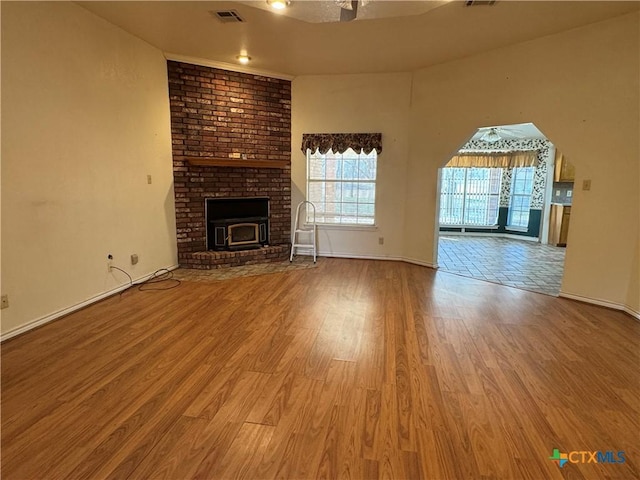 unfurnished living room with visible vents, baseboards, and wood finished floors