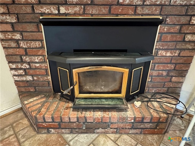 details featuring a wood stove and baseboards