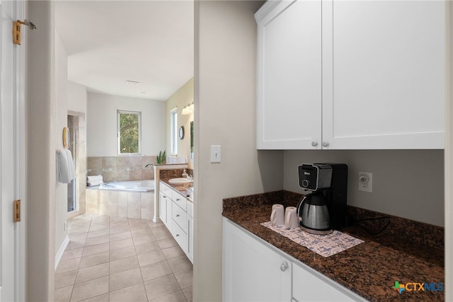 9063 Schoenthal Rd, San Antonio, TX 78266 - kitchen with white cabinets, dark stone countertops, and light tile patterned flooring