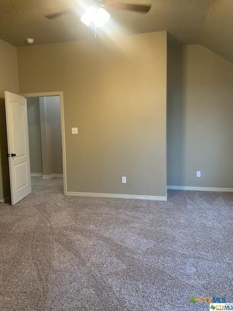 carpeted spare room with ceiling fan and lofted ceiling