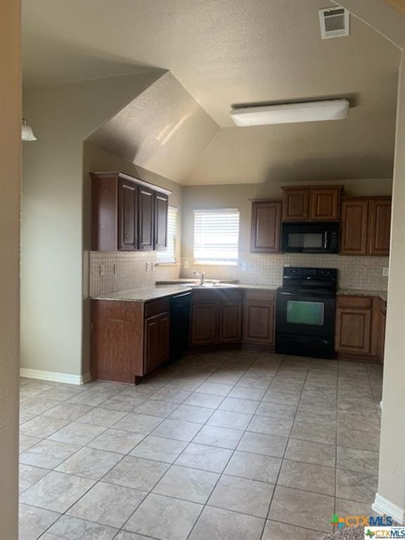 kitchen with decorative backsplash, light tile patterned floors, and black appliances