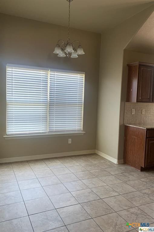 unfurnished dining area featuring a chandelier and light tile patterned floors