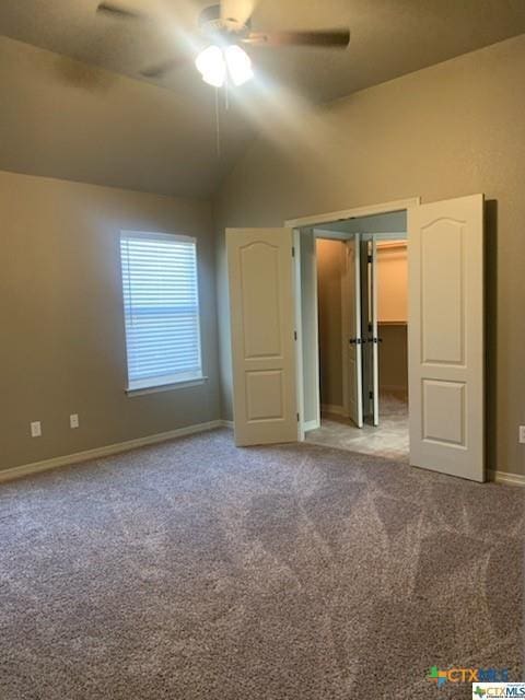 unfurnished bedroom with ceiling fan, carpet floors, and vaulted ceiling