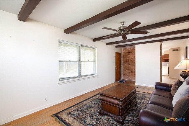 living area with baseboards, ceiling fan, beam ceiling, and wood finished floors