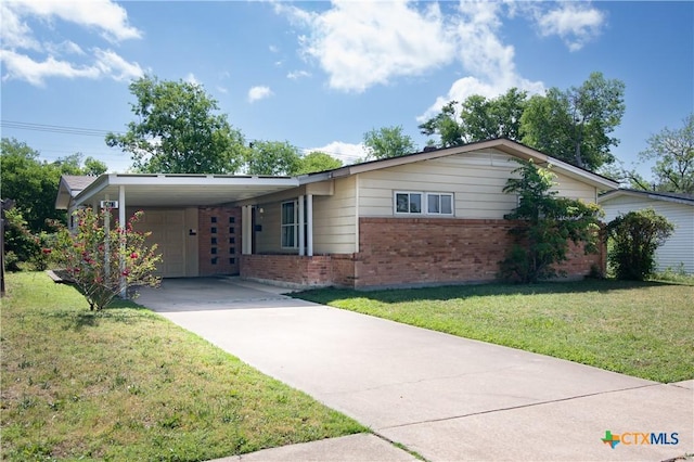 single story home featuring brick siding, an attached carport, driveway, and a front yard
