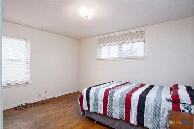 bedroom featuring baseboards and wood finished floors