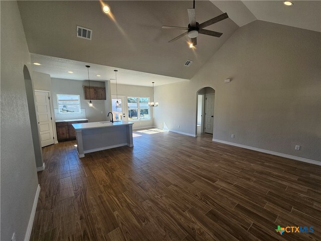 kitchen featuring arched walkways, open floor plan, and dark wood-type flooring