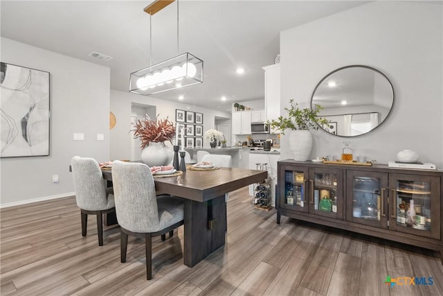 dining room featuring recessed lighting, visible vents, light wood-style flooring, and baseboards