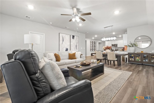 living room featuring light hardwood / wood-style flooring and ceiling fan