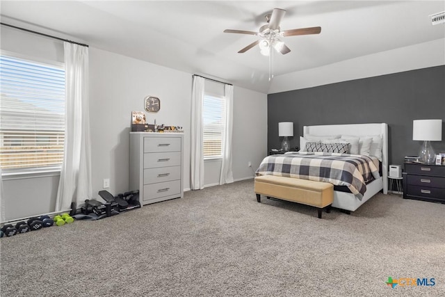 carpeted bedroom with visible vents and a ceiling fan