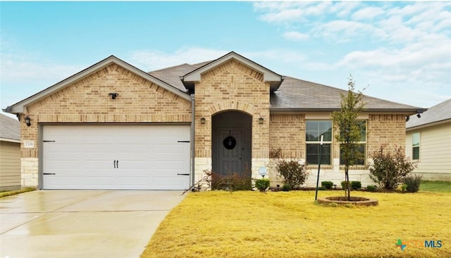 view of front of home with a garage, a front yard, concrete driveway, and brick siding