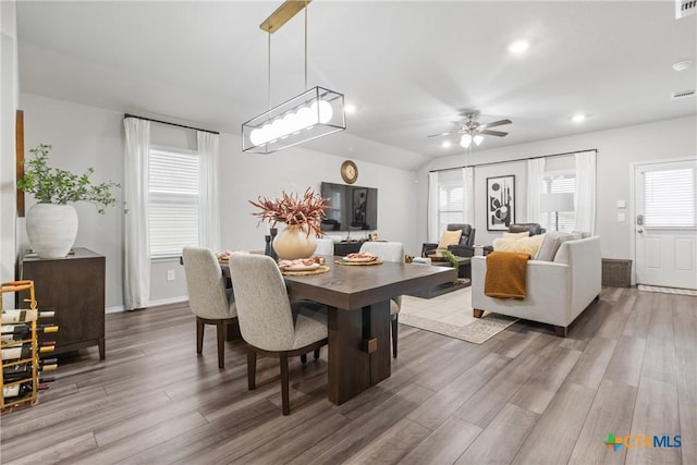 dining room featuring ceiling fan, wood-type flooring, and lofted ceiling