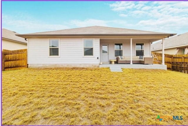 back of property with a patio area, outdoor lounge area, a lawn, and a fenced backyard