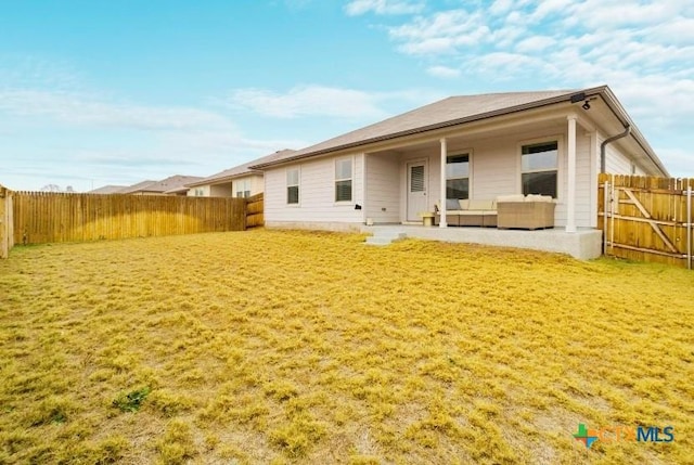 rear view of property featuring a fenced backyard, a yard, and a patio