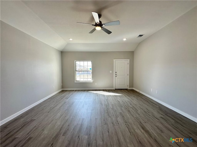 empty room featuring vaulted ceiling, ceiling fan, and dark hardwood / wood-style flooring