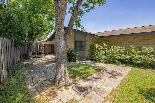 2506 Bon Aire Ave, Victoria, TX 77901 - view of side of home with brick siding and a patio