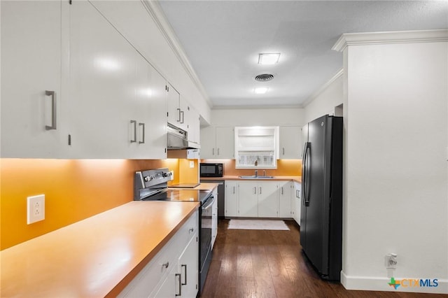 2506 Bon Aire Ave, Victoria, TX 77901 - kitchen with black appliances, under cabinet range hood, white cabinets, crown molding, and dark wood-style floors