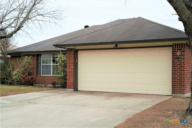 ranch-style house with driveway, brick siding, roof with shingles, and an attached garage