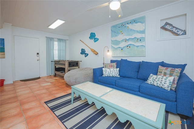 tiled living room with ceiling fan and ornamental molding