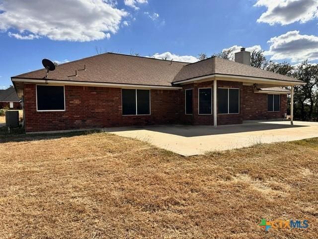 back of house with a lawn and a patio area