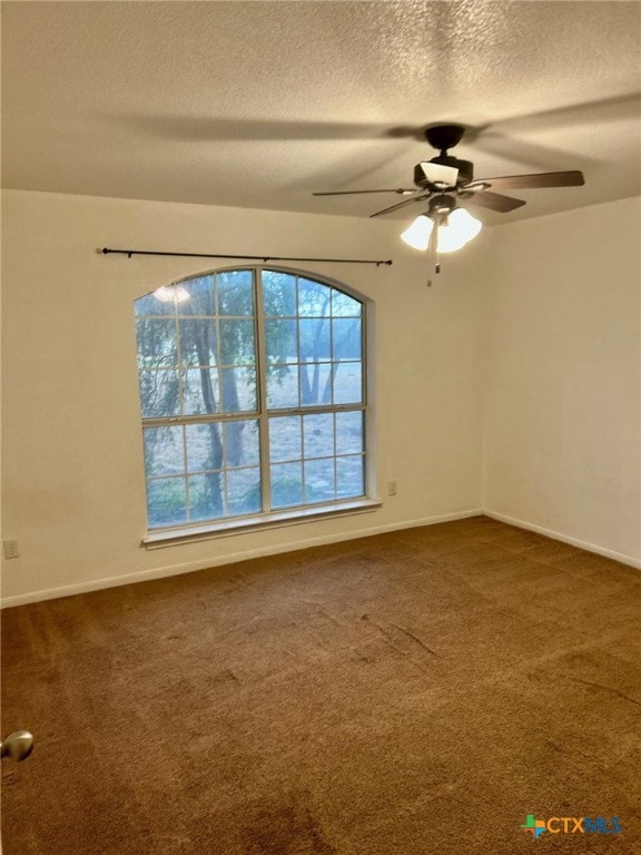 carpeted spare room featuring a textured ceiling and ceiling fan