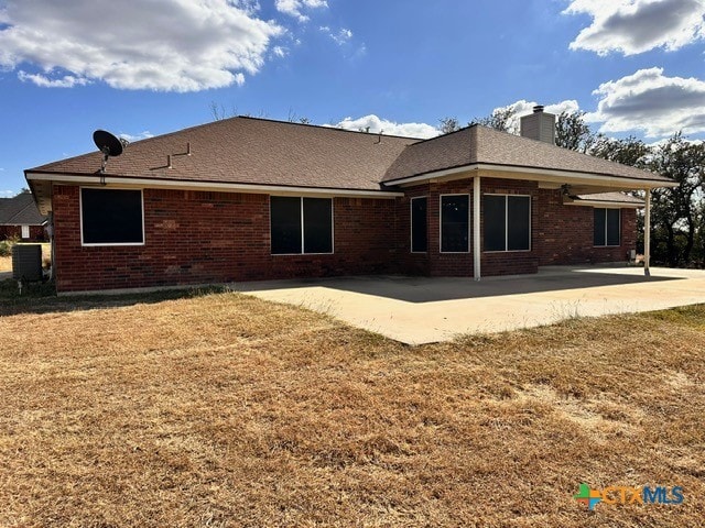 back of house featuring a lawn and a patio