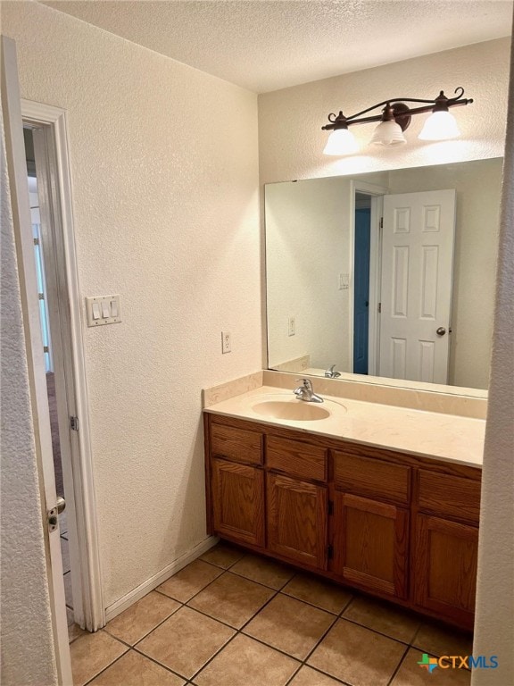 bathroom with tile patterned floors, vanity, and a textured ceiling