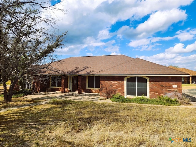 back of property with a yard and a patio