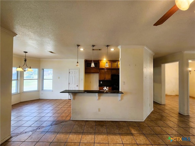 kitchen with crown molding, a breakfast bar area, ceiling fan with notable chandelier, tile patterned flooring, and decorative light fixtures