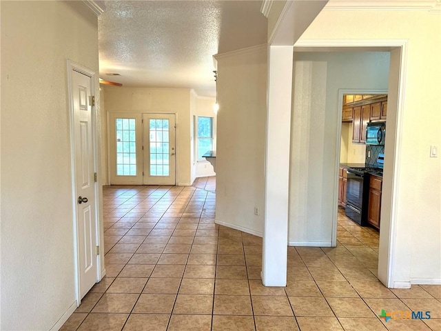 hall with ornamental molding, light tile patterned floors, and a textured ceiling