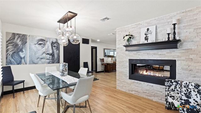 dining area featuring a fireplace and wood-type flooring