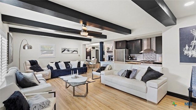 living room with beamed ceiling and light hardwood / wood-style flooring