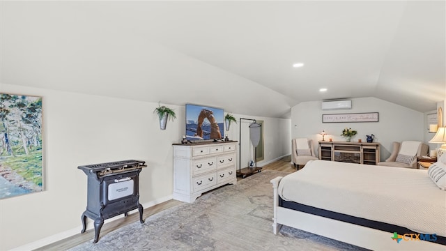 bedroom with a wall mounted AC, light wood-type flooring, and vaulted ceiling