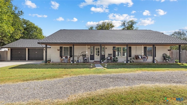 ranch-style home featuring a front lawn, a garage, and covered porch