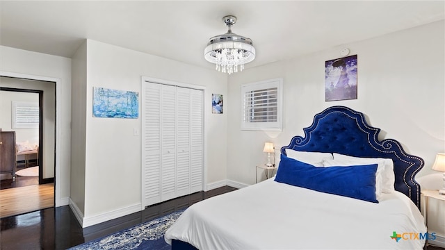 bedroom featuring a closet, an inviting chandelier, and dark hardwood / wood-style floors